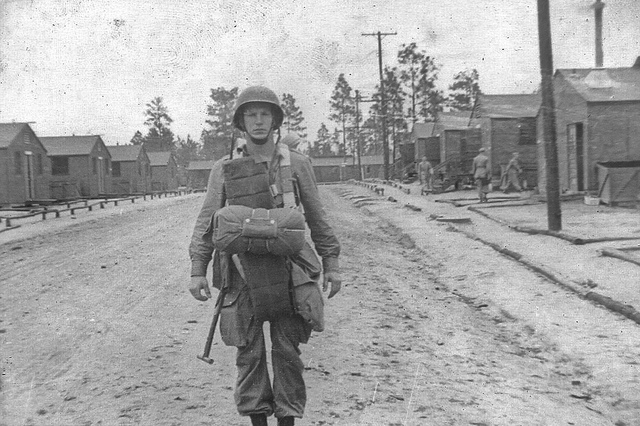 Un paracaidista, cargado con todo su equipo, en la calle central de Camp Toccoa